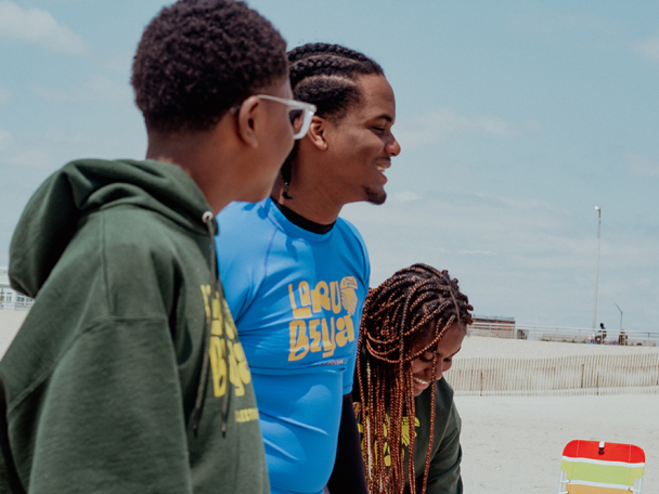group of community volunteers smile on the beach